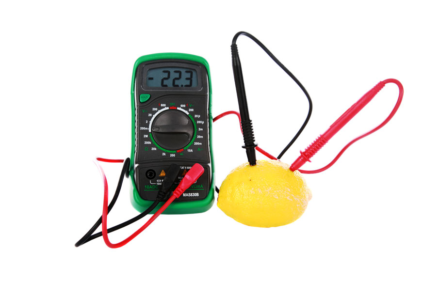 A multimeter measures electricity through a lemon