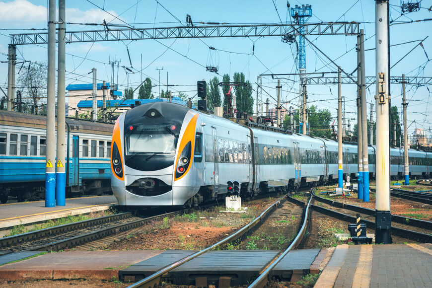 A high speed train is shown arriving at a railway platform