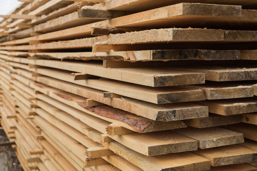 Lumber is carried by heavy duty cart wheels on a rail track