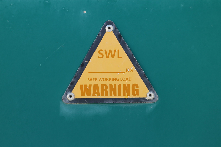 safe working load warning sign on green backgroundx