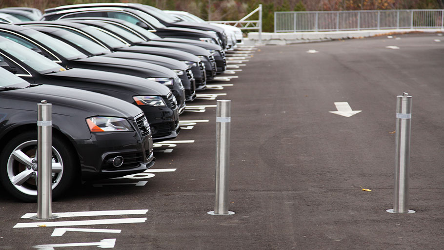 Reliance Foundry retractable bollards protecting a car lot.