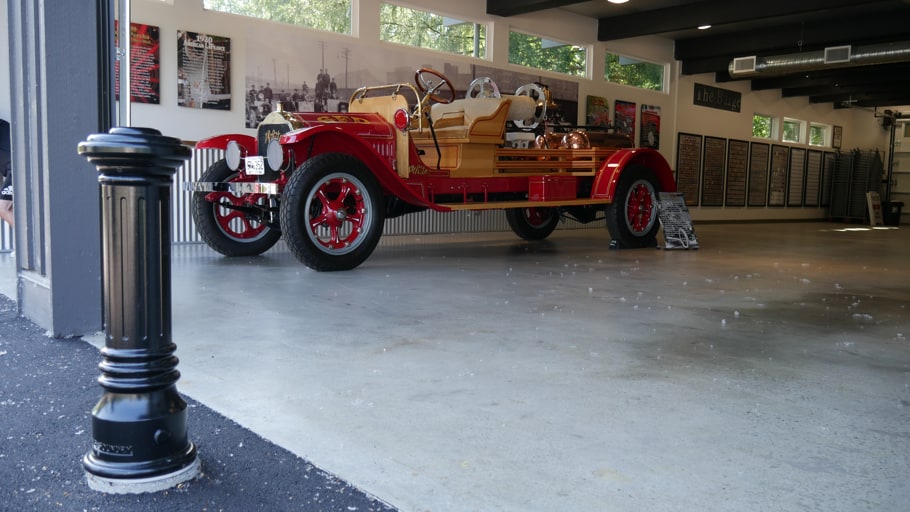 An R-7591 Bollard and an antique car sitting at a firehall