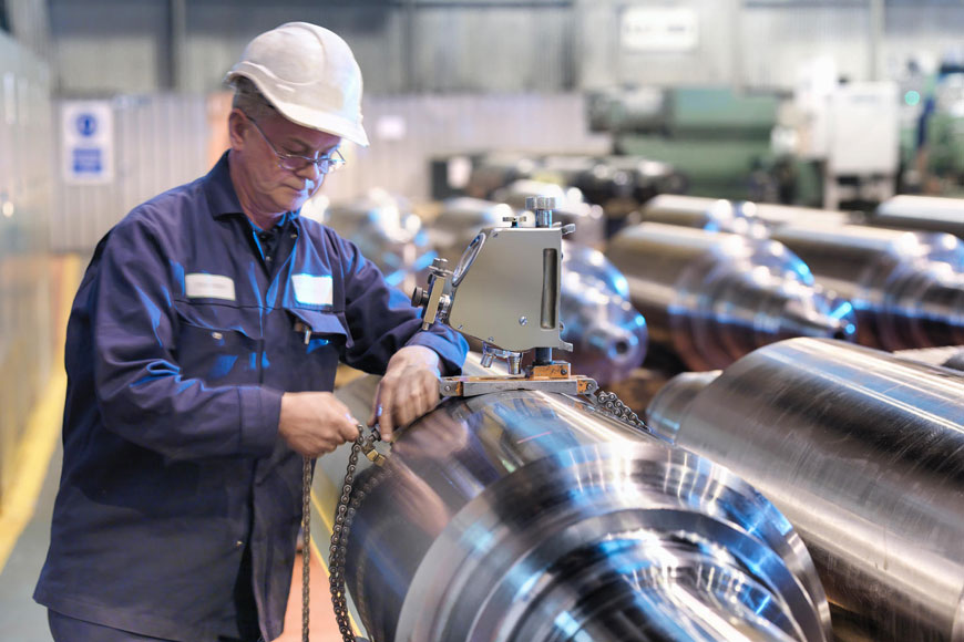 An engineer tests the hardness of steel in a metal production facility