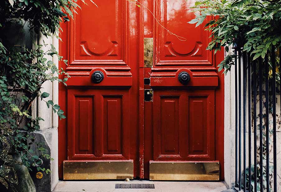 Red door with brass finger plate and brass kick plate.