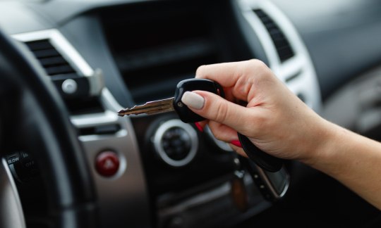 Car keys in the hand of a girl in the car interior