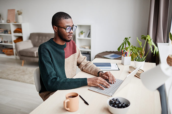 Man working at laptop in home office.