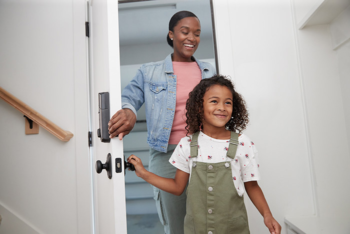 Mom and daughter entering home through attached garage door.