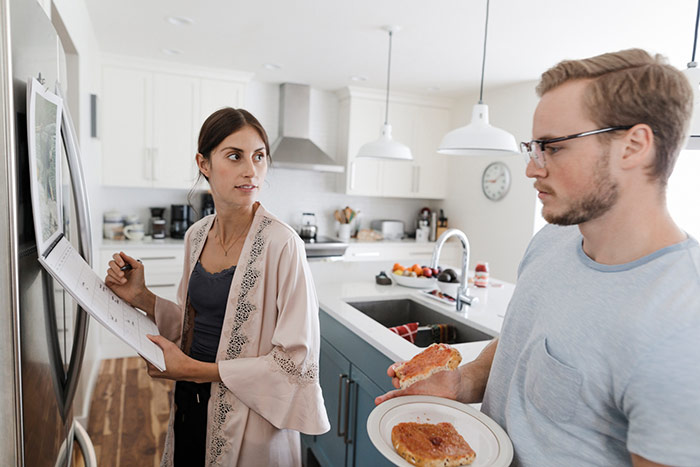 Wife and husband in kitchen filling our family calendar.